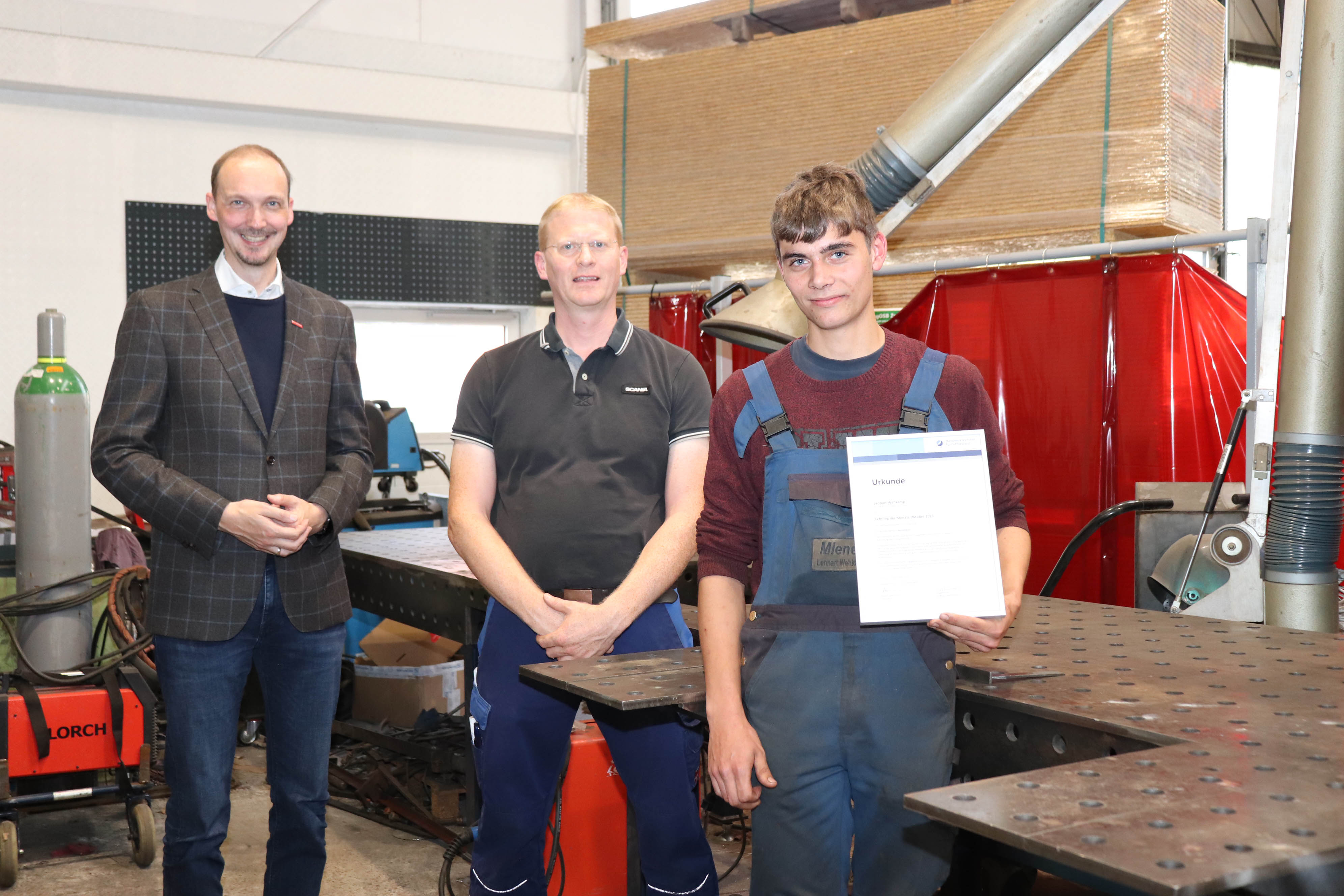 Dirk Bleeker (v.l.) gratulierte Betriebsinhaber Johann Bogena und Azubi Lennart Wehkamp zur Auszeichnung zum Lehrling des Monats.