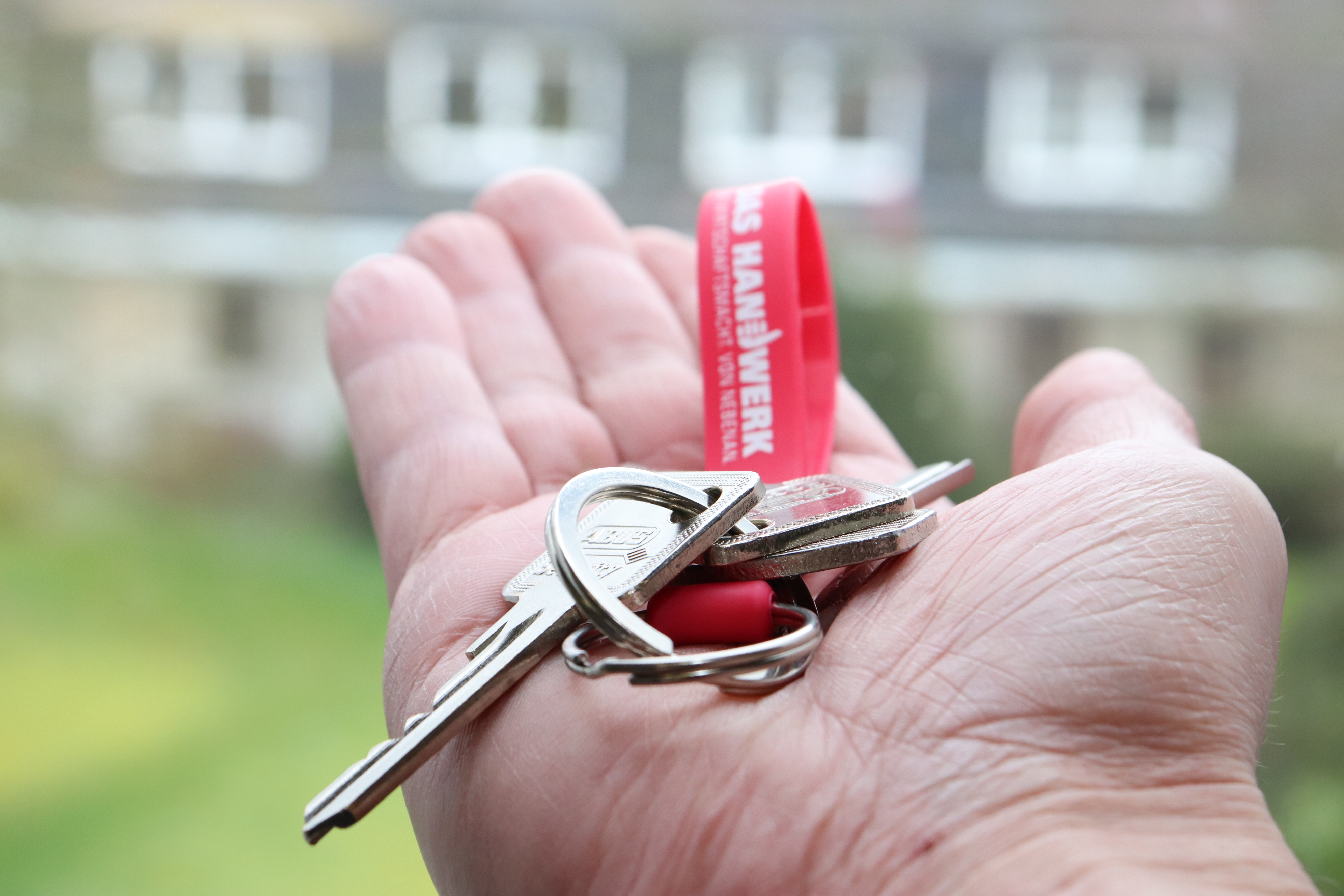 Eine Hand die einen Schlüsselbund in der Hand hält.