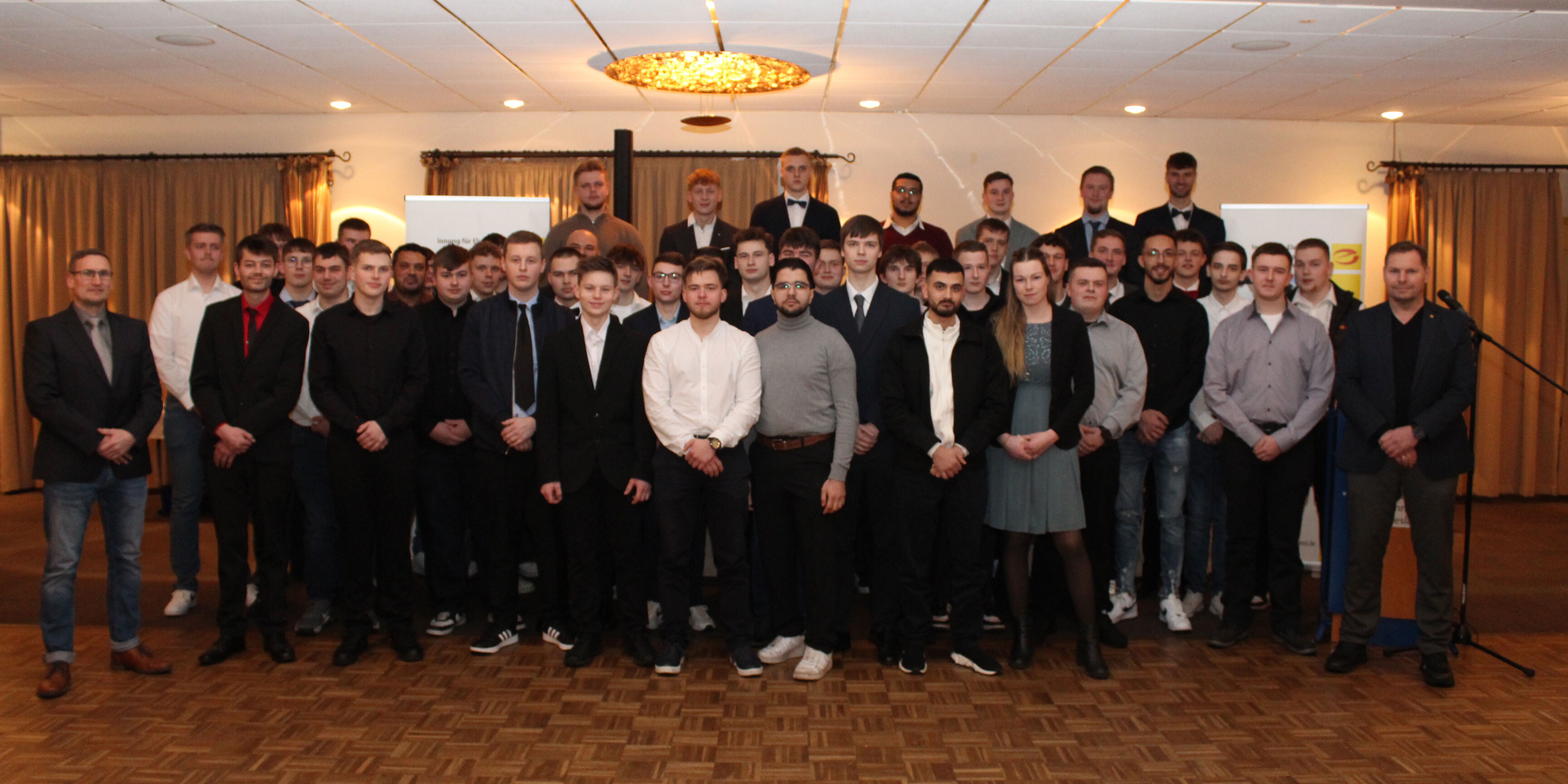 KI generiert: Eine große Gruppe von Menschen posiert in einem Veranstaltungsraum für ein Gruppenfoto.