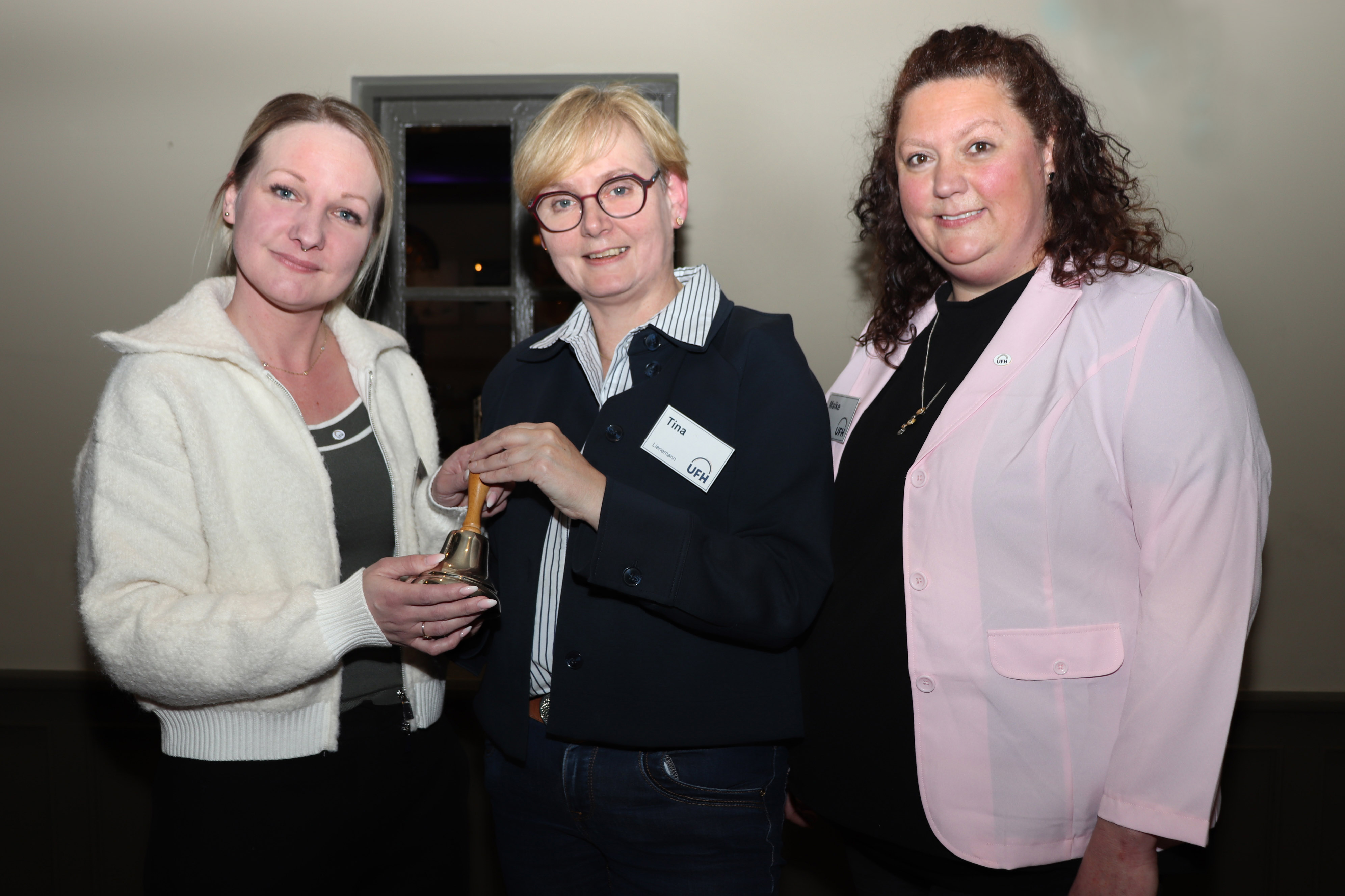 Tina Lienemann (Holtrop, Mitte) überreicht die UFH-Sitzungsglocke an die 1. Vorsitzende Lisa Wermuth (Westerholt, links) und die 2. Vorsitzende Maike Rector (Hage, rechts). 