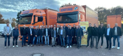Innungsmitglieder stehen mit Mitarbeitern von Schüt-Duis vor den Firmen-LKW