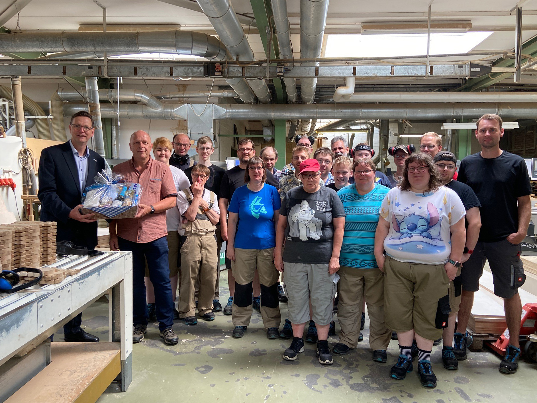 Wilhelm Eden, Obermeister der Tischler-Innung Leer (2. v. li.), überreichte Geschäftsführer Erwin Koops (li.) einen Präsentkorb zum 60. Vereinsjubiläum der Lebenshilfe Leer. Darüber freute sich auch das inklusive Tischlerei-Team um die Gruppenleiter Frank Peters (ganz re.) und Arne Pfeiffer (Mitte hinten). 