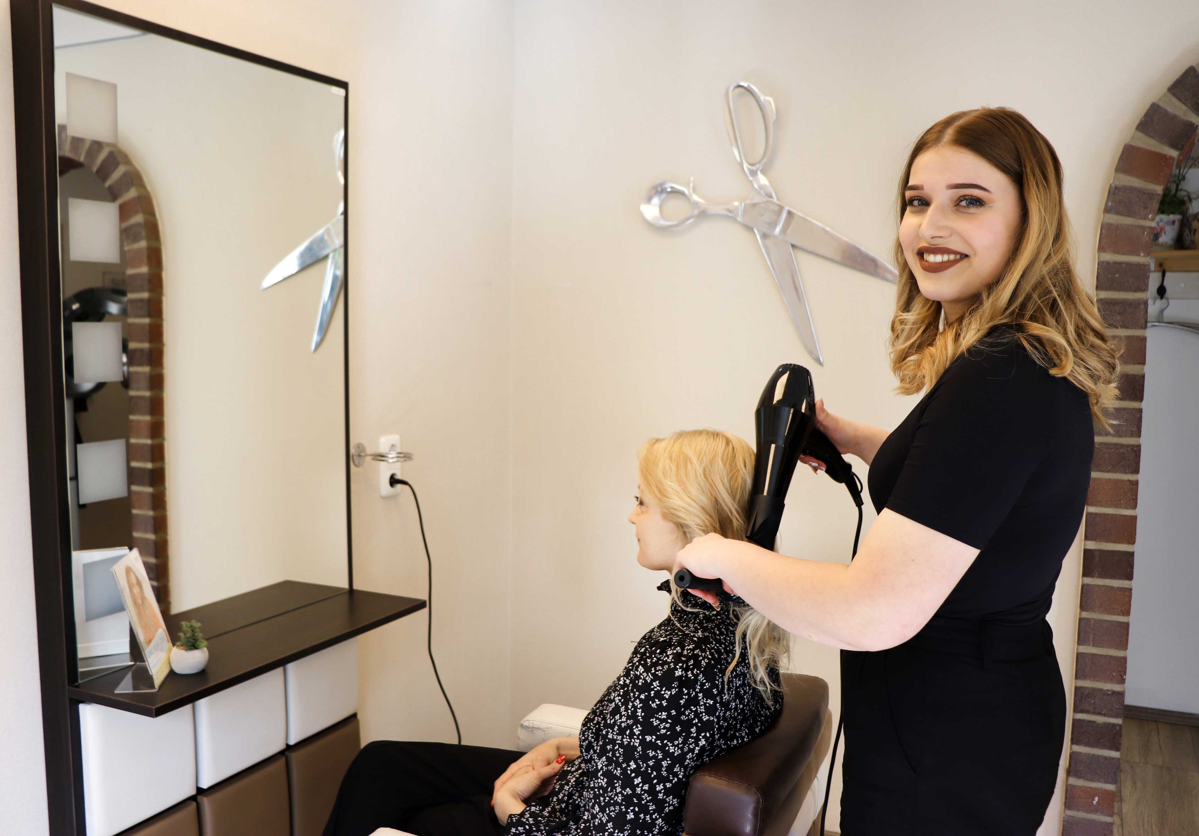 Fenja Tjards wie sie einer Kundin die Haare frisiert.