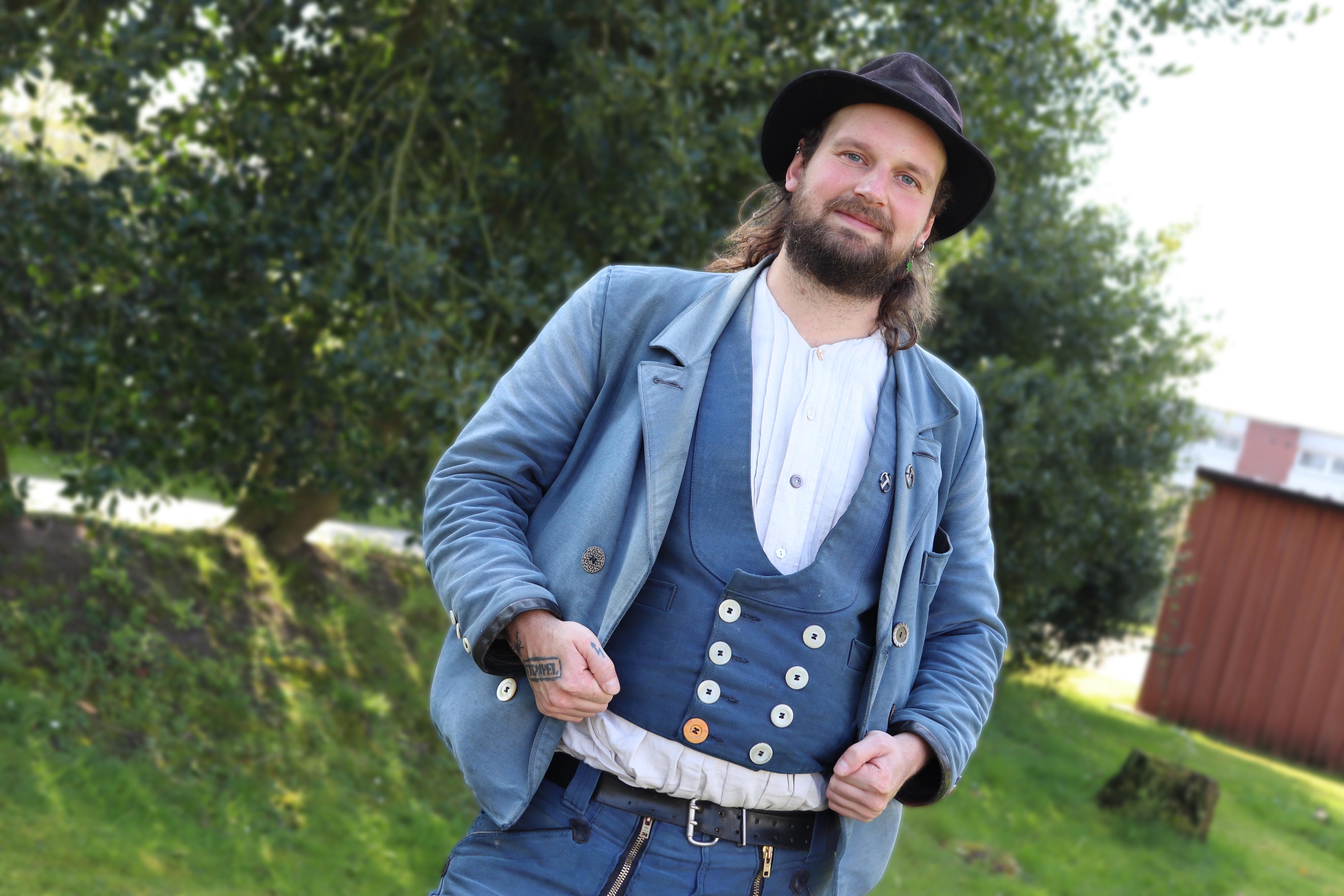 KI generiert: Ein Mann steht draußen und trägt traditionelle Handwerkerkleidung mit einem Hut.