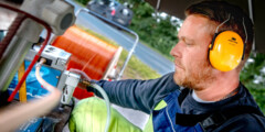 Ein Glasfaser-Monteur mit Gehörschutzbei der Arbeit.