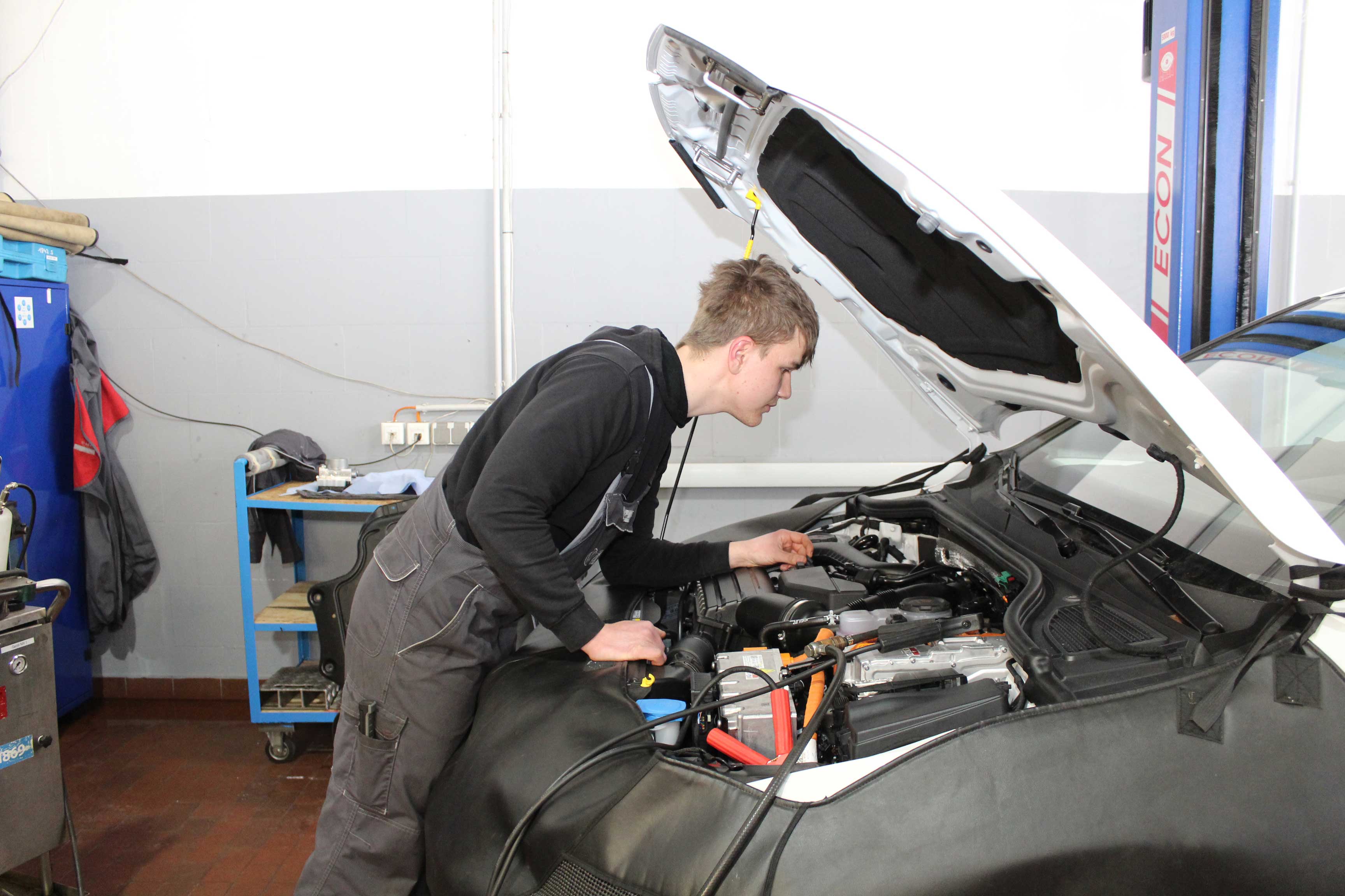  Justus Richter, der grade dabei ist ein Auto zu Reparieren.