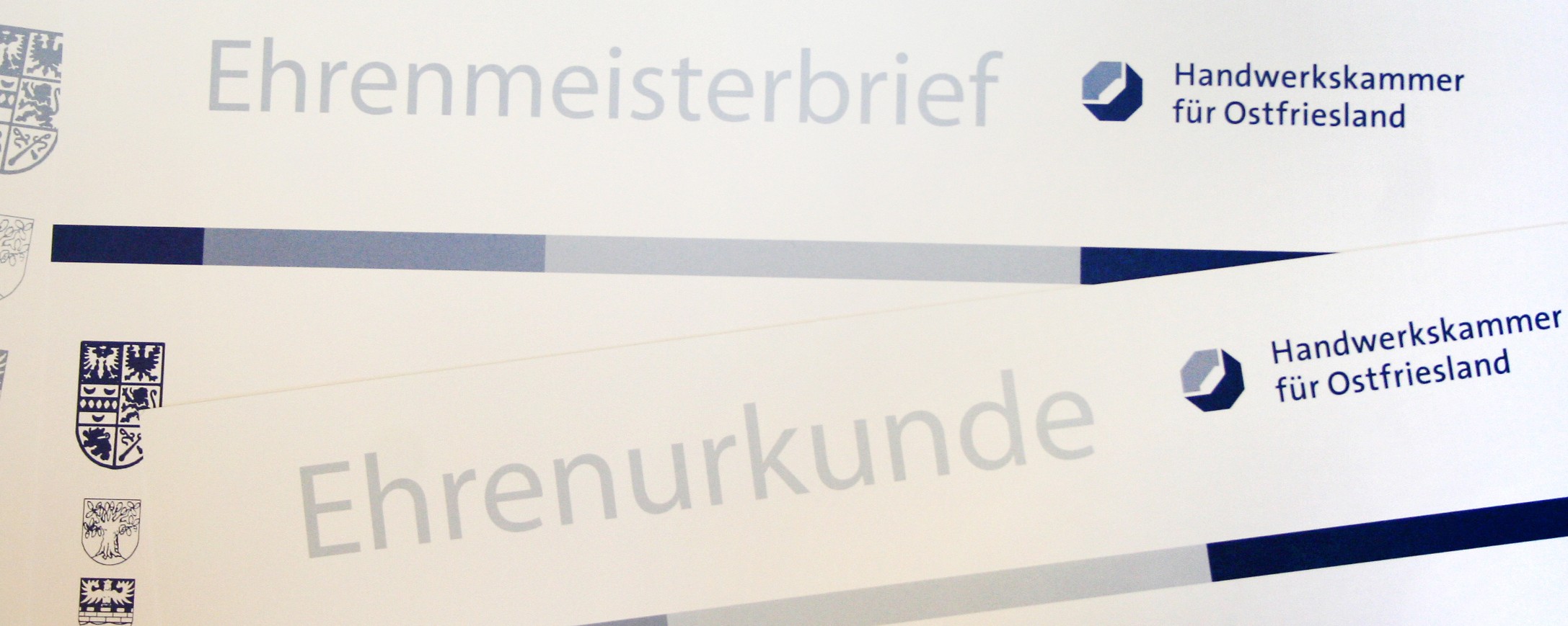 Mehrere Ehrenurkunden liegen aufeinander.
