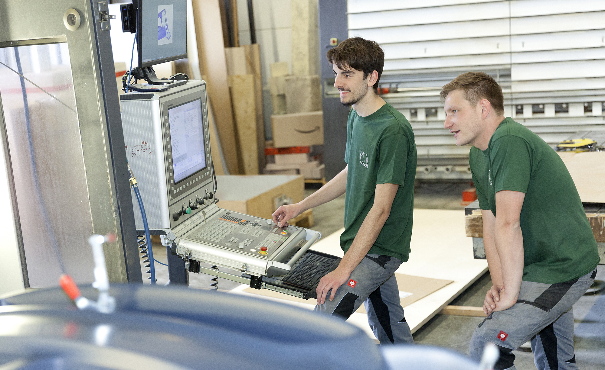 KI generiert: Das Bild zeigt zwei Männer, die an einer CNC-Maschine arbeiten.
