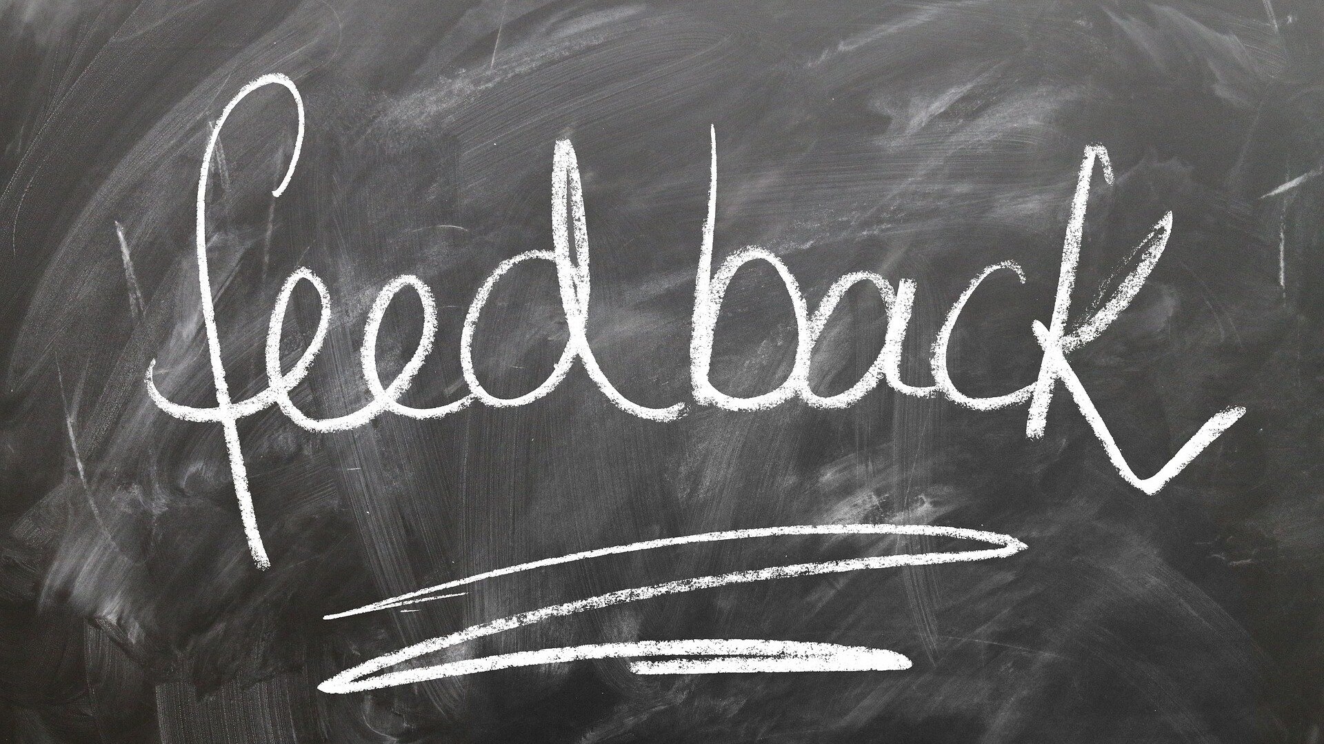 KI generiert: Das Bild zeigt das Wort "feedback", das mit Kreide auf eine Tafel geschrieben wurde.