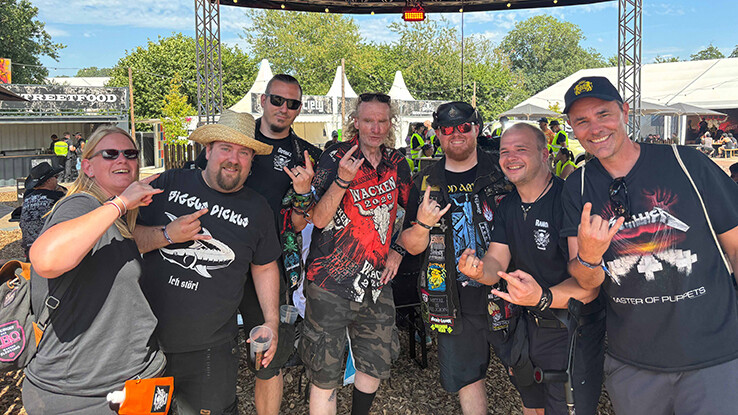 Das Bild zeigt eine Gruppe von sieben Personen auf dem Wacken Open Air Festival.
