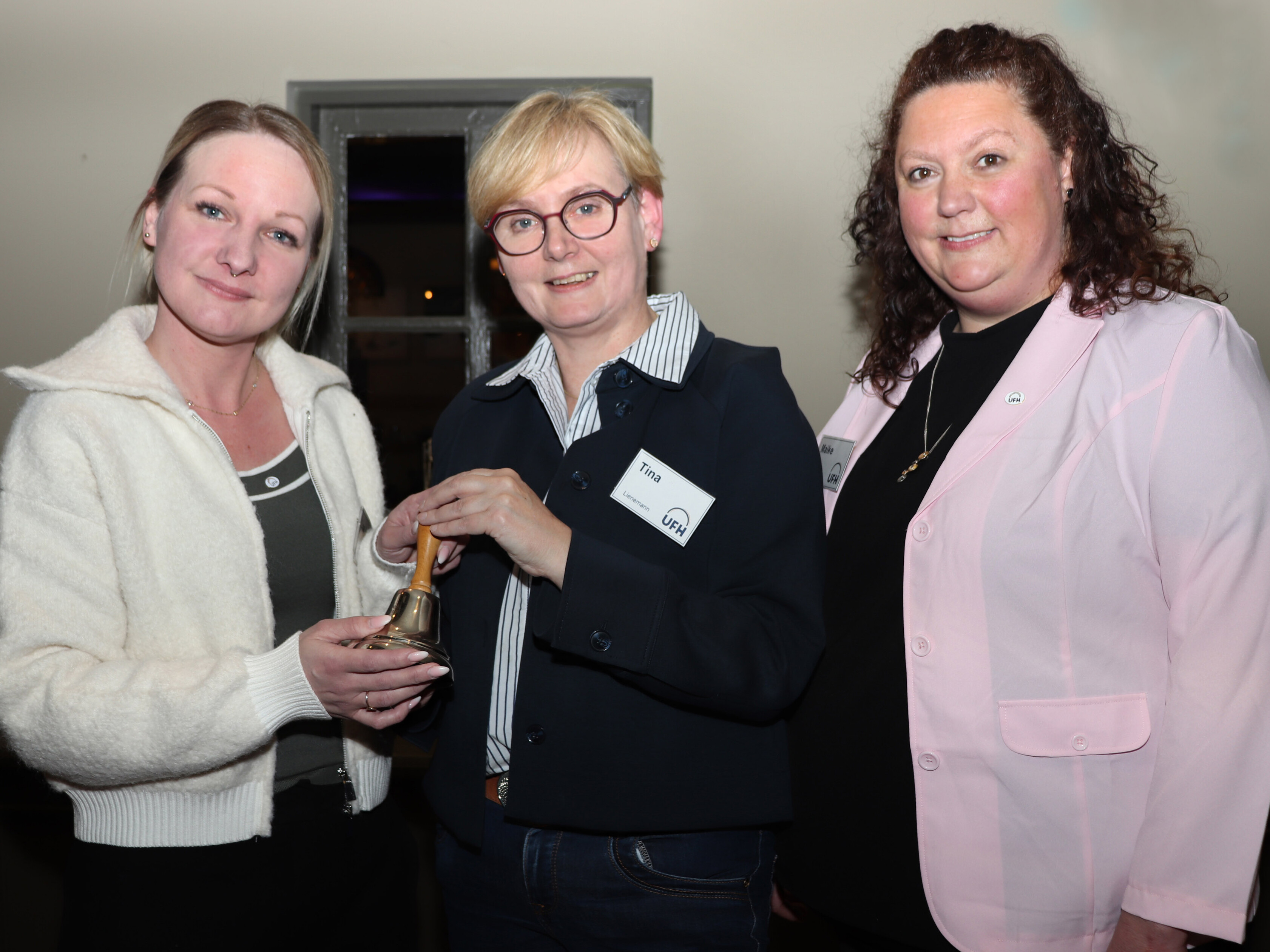 Tina Lienemann (Holtrop, Mitte) überreicht die UFH-Sitzungsglocke an die 1. Vorsitzende Lisa Wermuth (Westerholt, links) und die 2. Vorsitzende Maike Rector (Hage, rechts). 