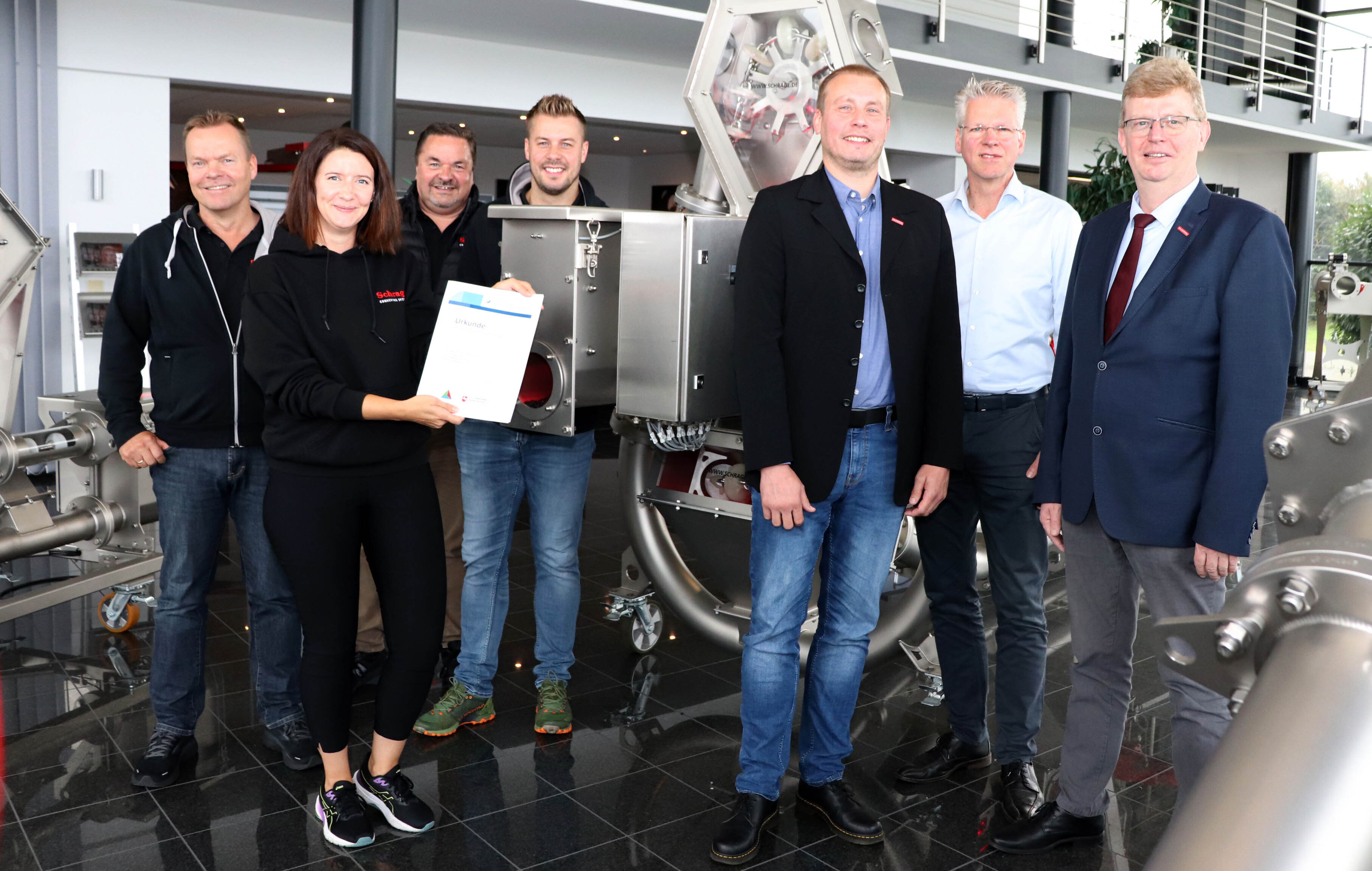 Geschäftsführer Frank (l.) und Ralf Schrage (3.v.l.) sowie Sohn Daniel Schrage (4.v.l.) und Projektleiterin Lena Bashagen (vorne). Es gratulieren (von rechts) von der Handwerkskammer Präsident Albert Lienemann, Thomas Harms und Michael Sandmann (HWK OL). 