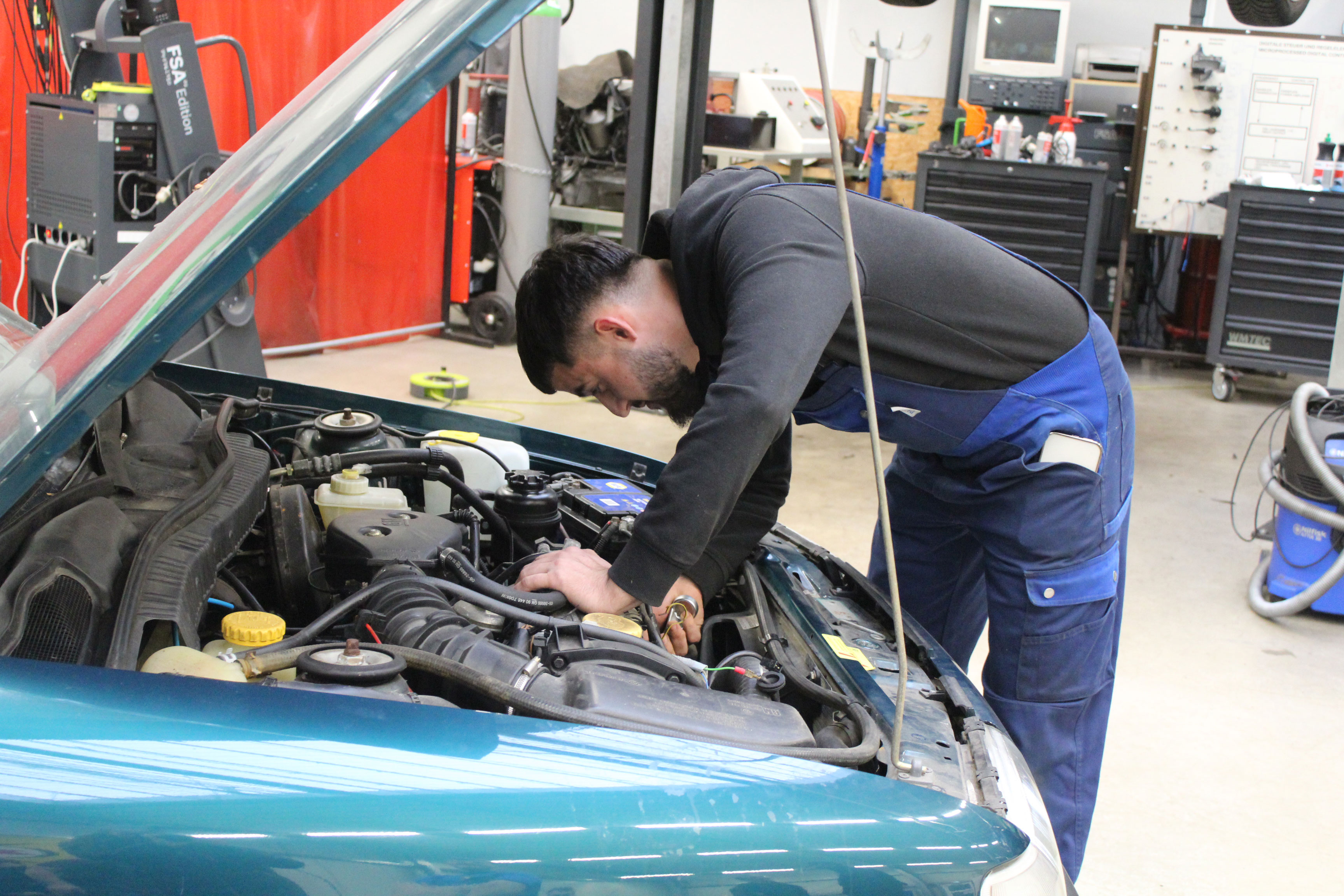Ein Kfz-Mechaniker arbeitet an einem Auto.