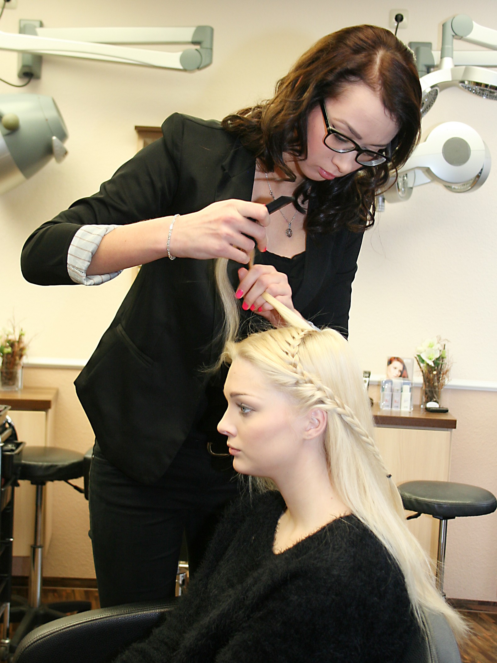 Ein Lehrling frisiert einem anderen Schüler die Haare.