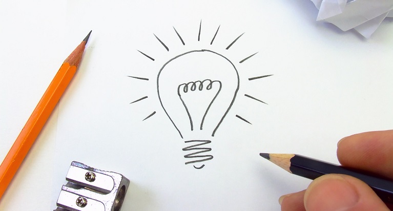 Eine Person zeichnet eine Glühbirne; im Hintergrund liegen ein Stift und ein Anspitzer.