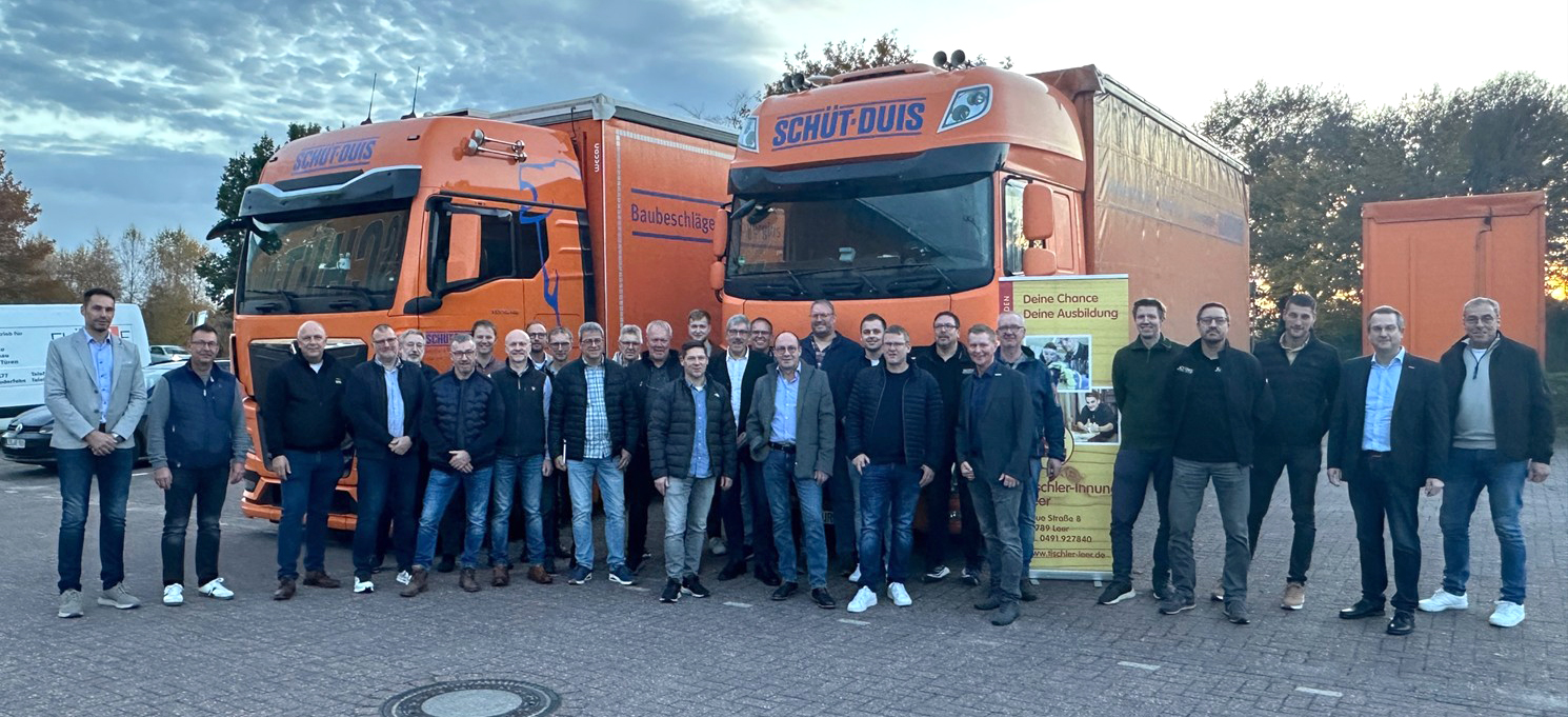 Innungsmitglieder stehen mit Mitarbeitern von Schüt-Duis vor den Firmen-LKW