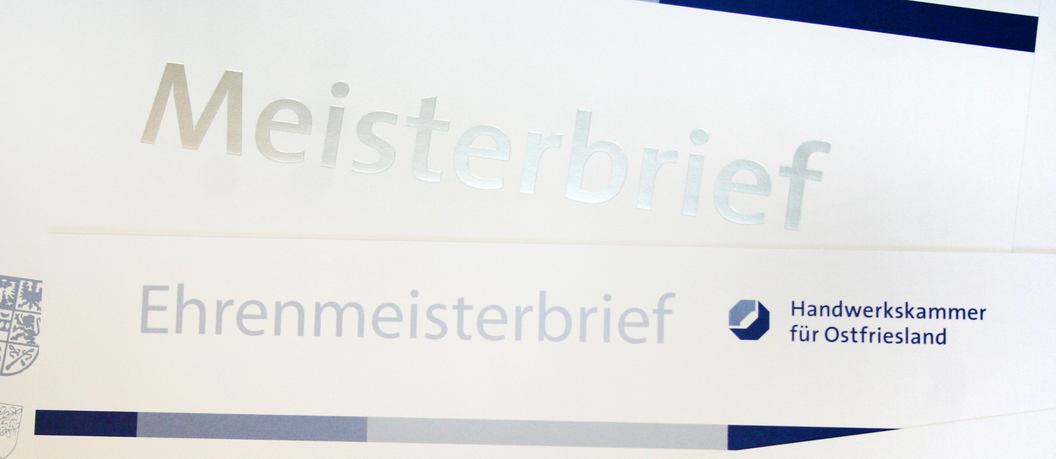 Meisterbriefe, Ehrenmeisterbriefe und weitere Ehrenurkunden liegen verstreut auf dem ganzen Bild.