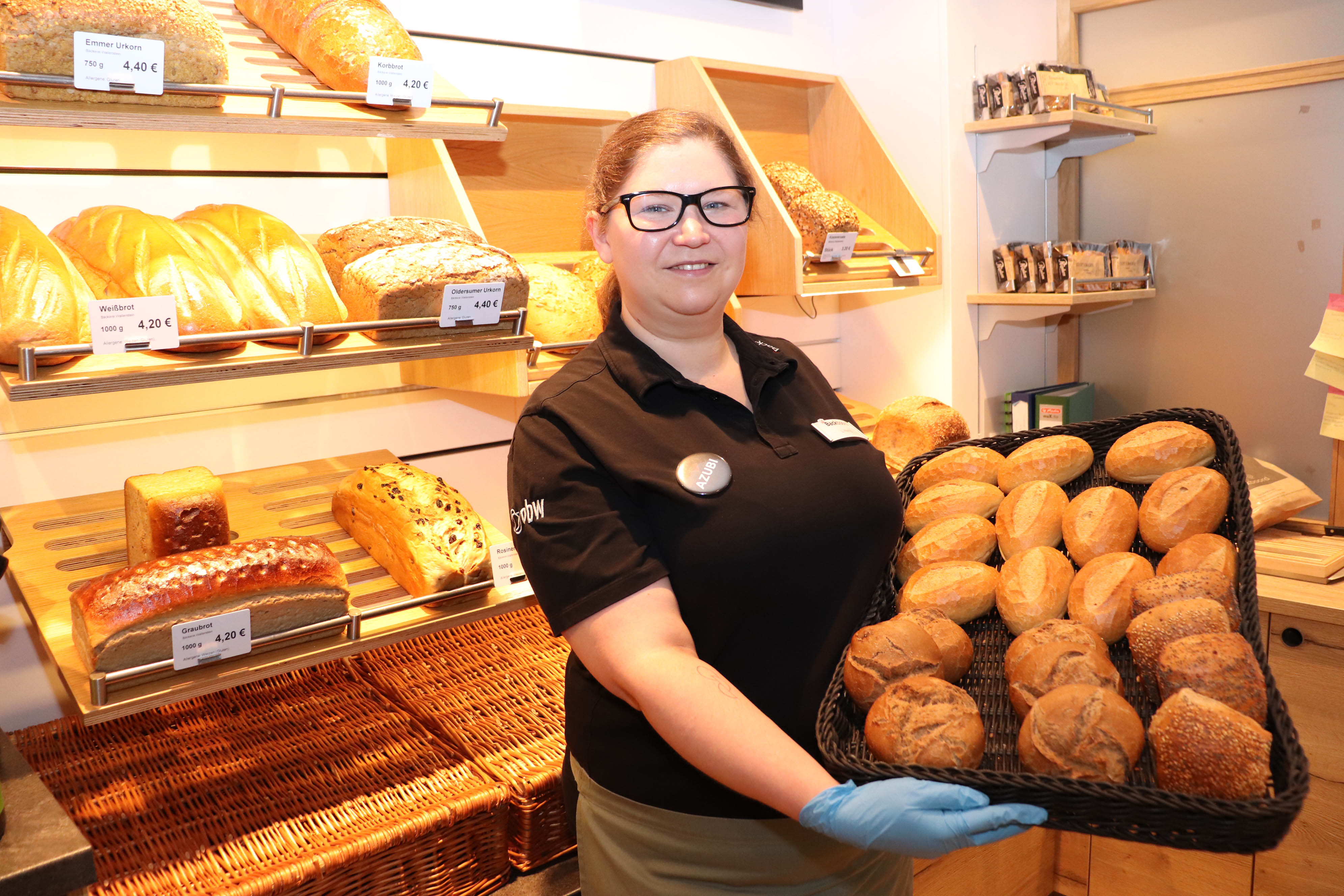Lisa Rietig, wie sie ein Blech mit Brötchen in die Kamera hält.