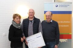 Die Geschäftsführerin Angela Mandel und der stellvertretende Leiter des Berufsbildungszentrums in Aurich, Johannes Best (rechts), gratulieren dem Jubilar.
