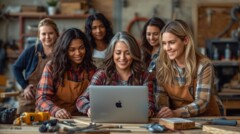 KI generiert: Eine Gruppe von Frauen in Holzfällerhemden und Schürzen betrachtet gemeinsam einen Laptop in einer Werkstatt.