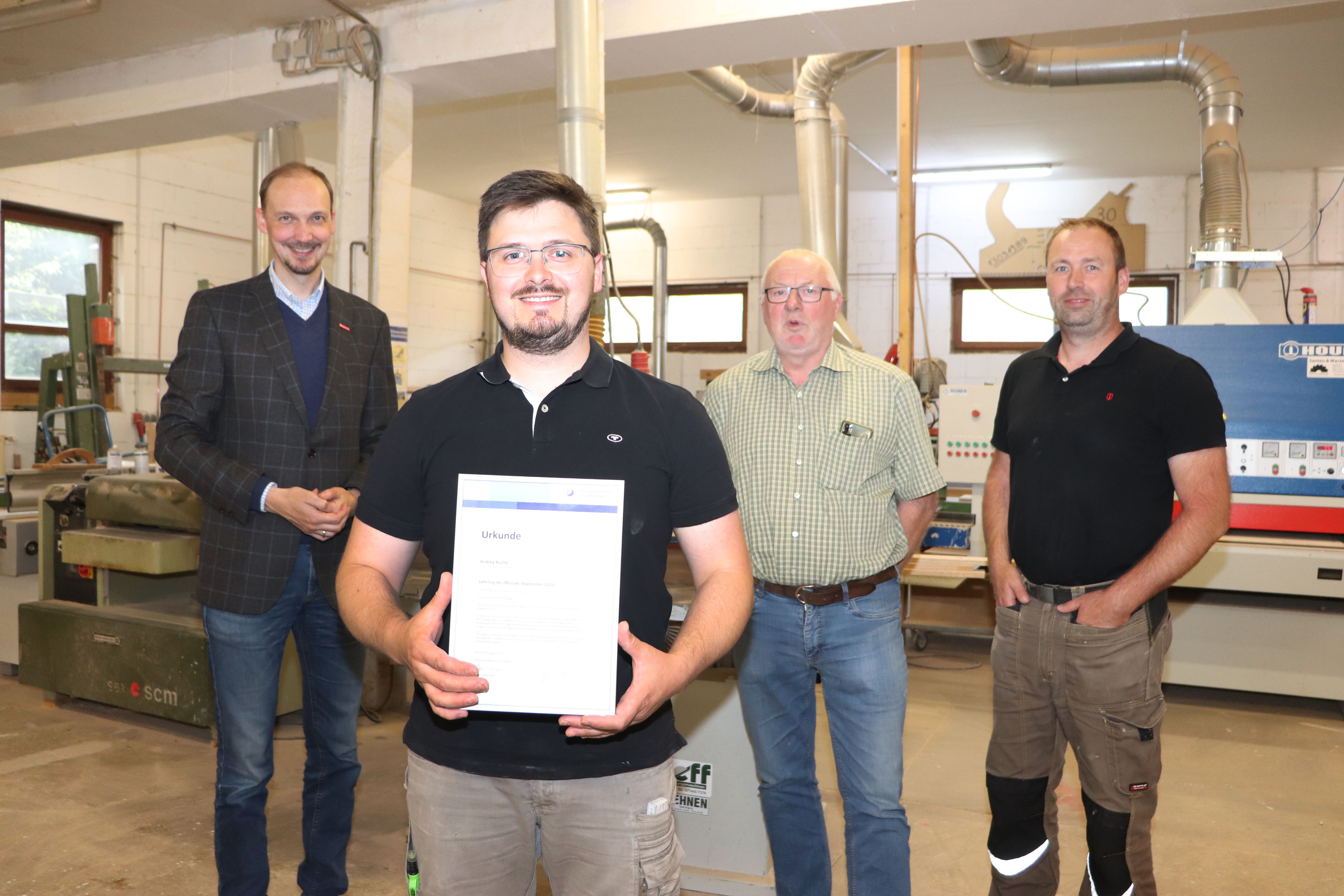 Dirk Bleeker (v.l.) besuchte den Betrieb Bau- und Möbeltischlerei Wilberts und gratulierte Umschüler Andrey Büche sowie Ode und Ingo Wilberts zur Auszeichnung.