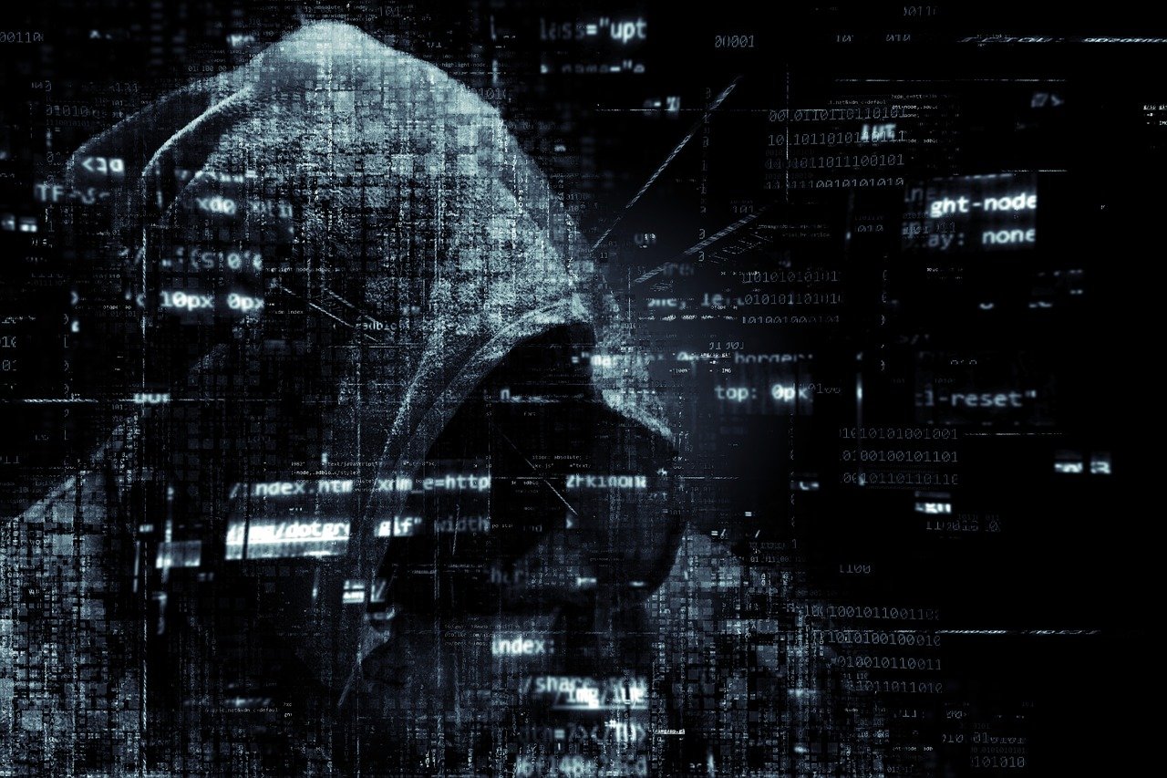 KI generiert: Ein vermummter Hacker vor einem Hintergrund aus Computercode.